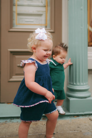 Little girl playing in a girls short set with flutter-sleeve swing top and matching shorts, designed to coordinate with the Margot Bubble.